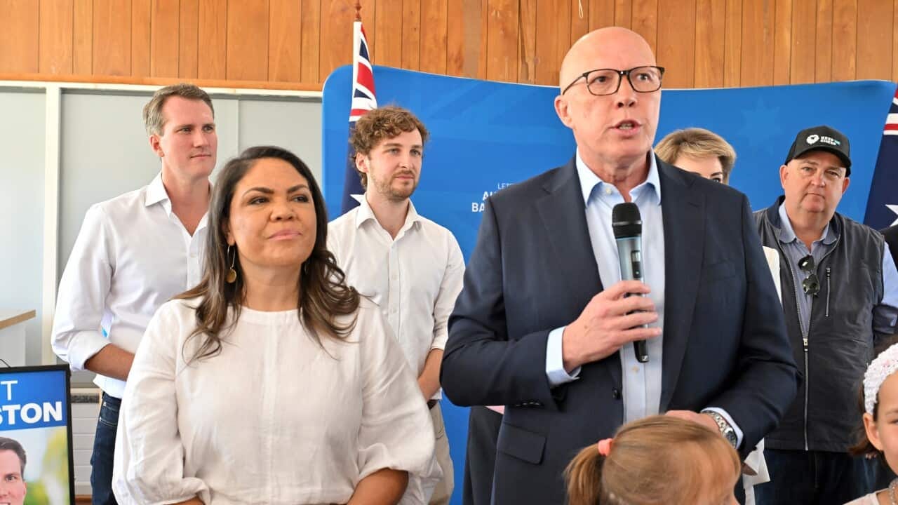 A woman and a man speak at a campaign rally. 