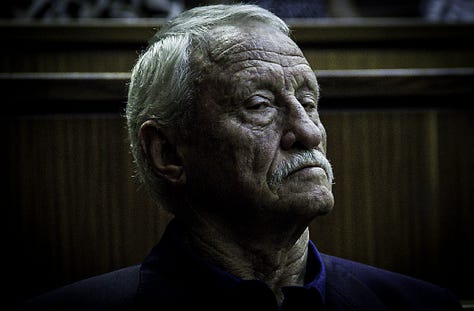 An old white man with a hard face, the face of an askari, a turned guerrilla, and a former Security Police explosives expert