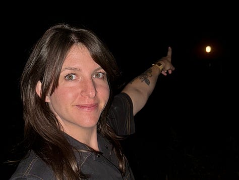 photo 1: meg's hands make a heart shape to frame the moon, which looks like a sun. photo 2: Andrea wears a shirt with a moon on it and holds up a sign that says "I'd rather have a sky without a moon in it than a poem without a moon it in." Photo 3: an excited, bewildered Megan tries to point to the giant moon in the sky. her aim is off.