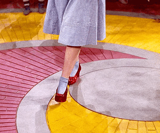 This may contain: a woman is walking down the runway wearing red shoes