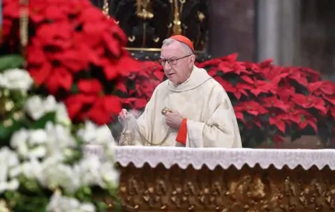 Getty Images Cardinal Pietro Parolin wears a red cap on his head while he holds a smoking urn on a table against a backdrop of red chrysantheums during the Holy Mass on the occasion of the Solemnity of Mary, Mother of God, in St. Peters Basilica, Vatican City on 1 January.