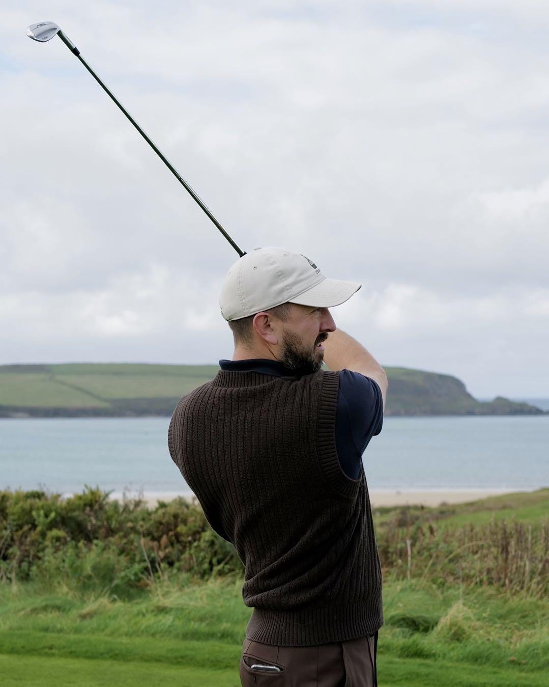 A person swinging a golf club

Description automatically generated