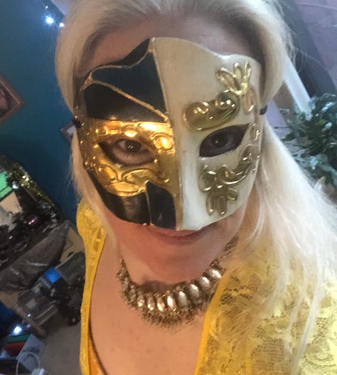 Gallery of sparkly costumes and costuming supplies, two wigs in golden brown on mannequin heads, and gold-leaf leather in a pile on the floor.