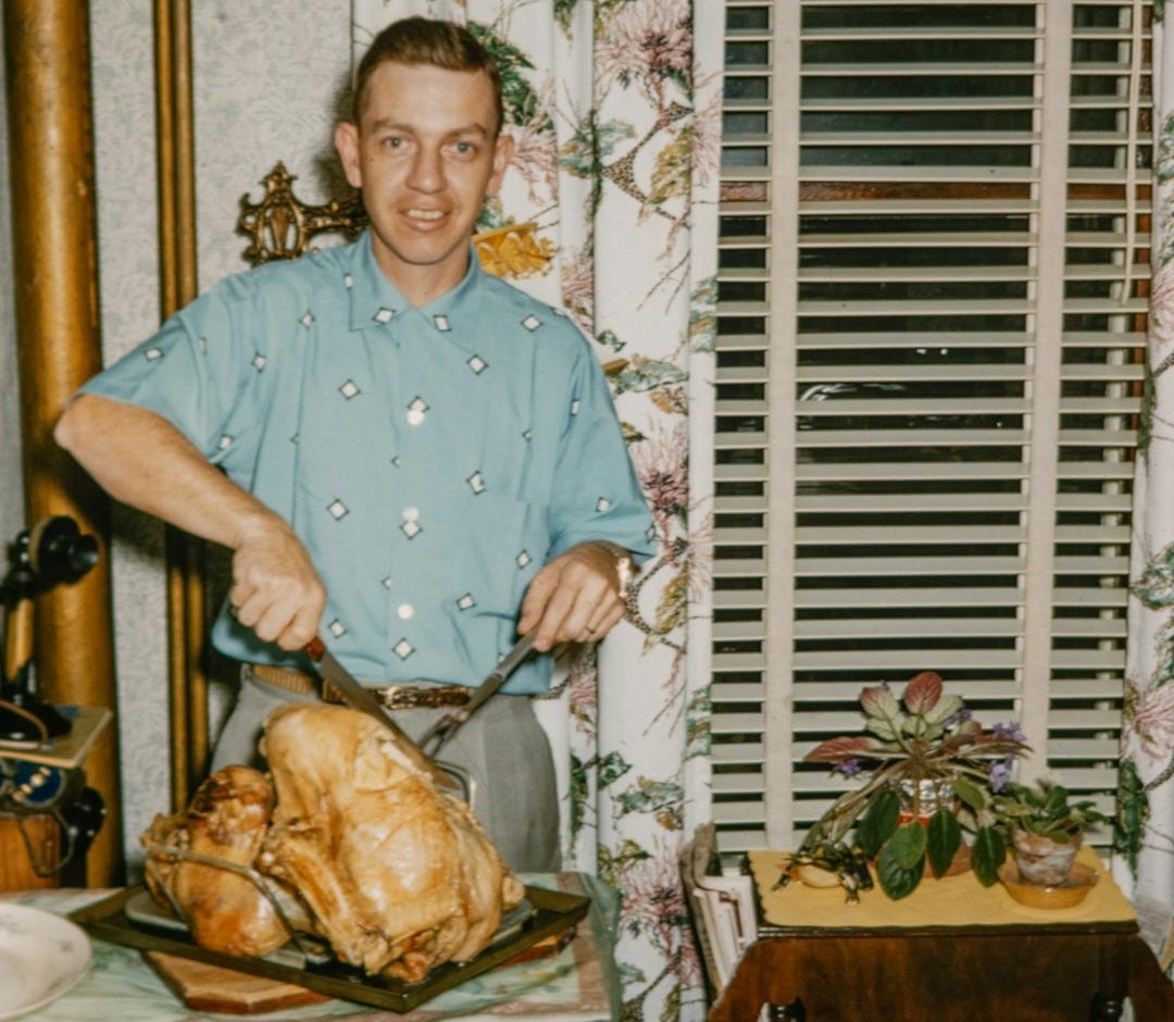 a man standing in front of a turkey on a table a man standing in front of a turkey on a table