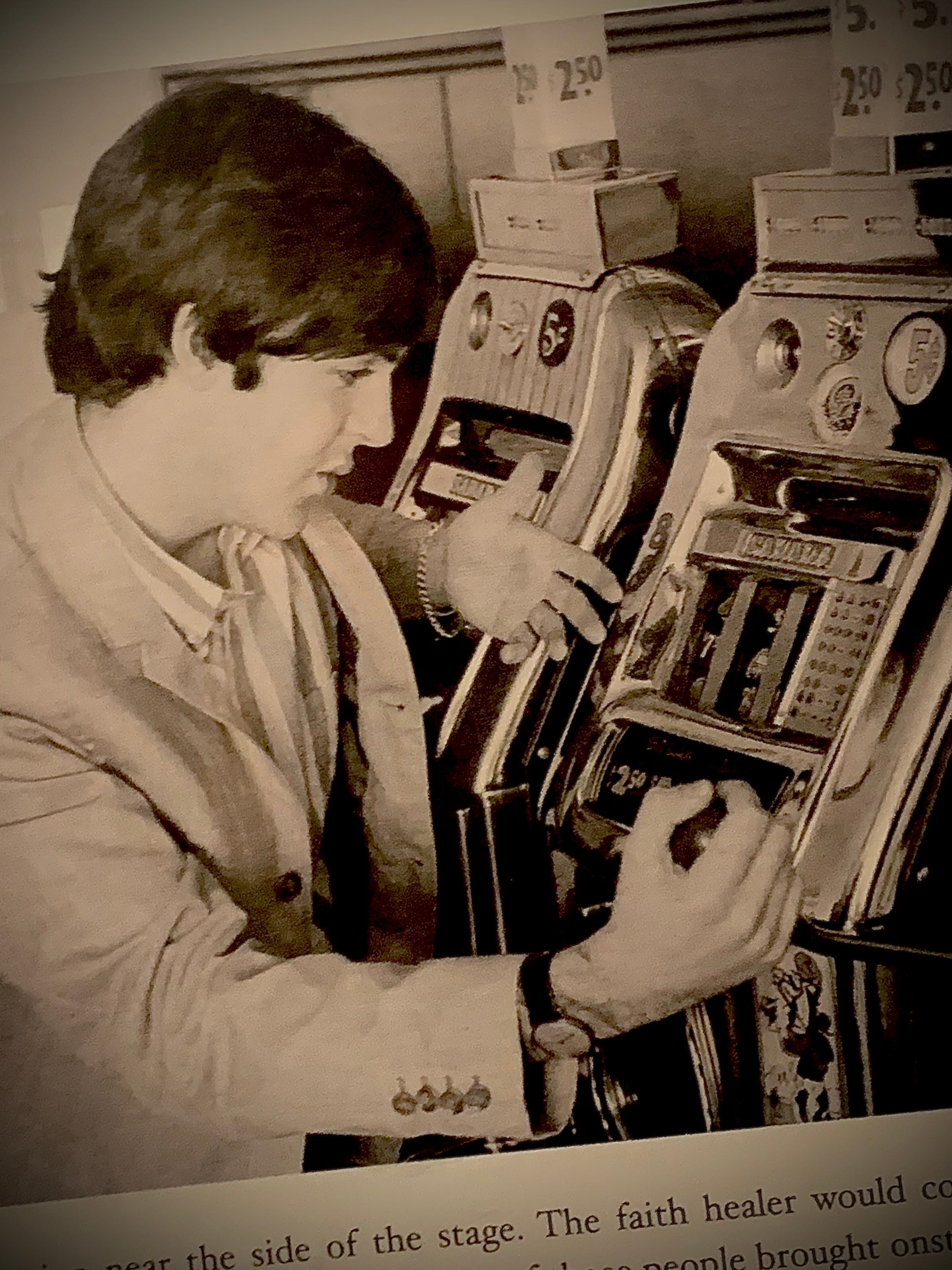 Paul McCartney playing two slot machines with $2.50 signs