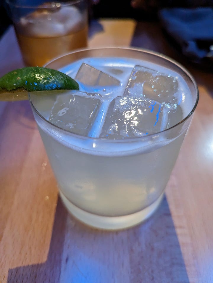 Left to right: Harana (clear drink with a lime garnish); Pecan Pie Old Fashioned (a warm light brown liquor with a pecan on top of the ice)