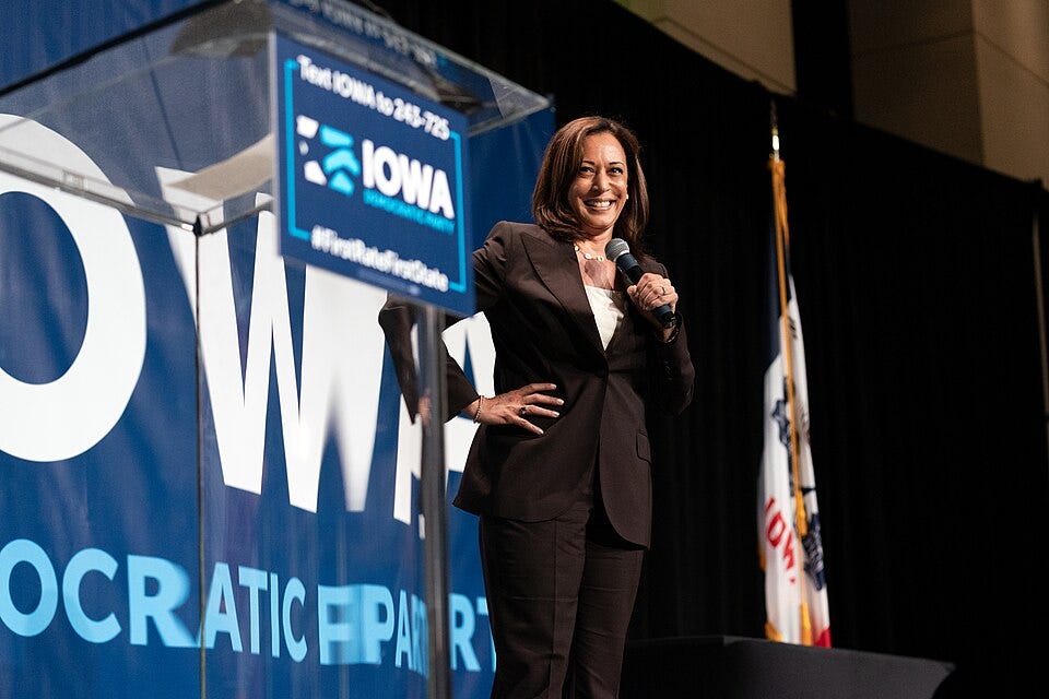 Kamala Harris standing on an Iowa stage with her hand on her hip