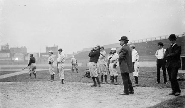 Bill Armour in suit and tie, standing with a group of uniformed players on a baseball field. Bill Armour in suit and tie, standing with a group of uniformed players on a baseball field.