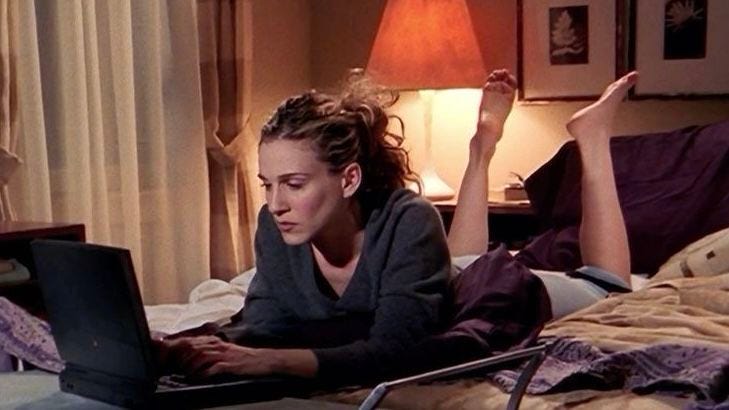 This may contain: a woman laying in bed using a laptop computer