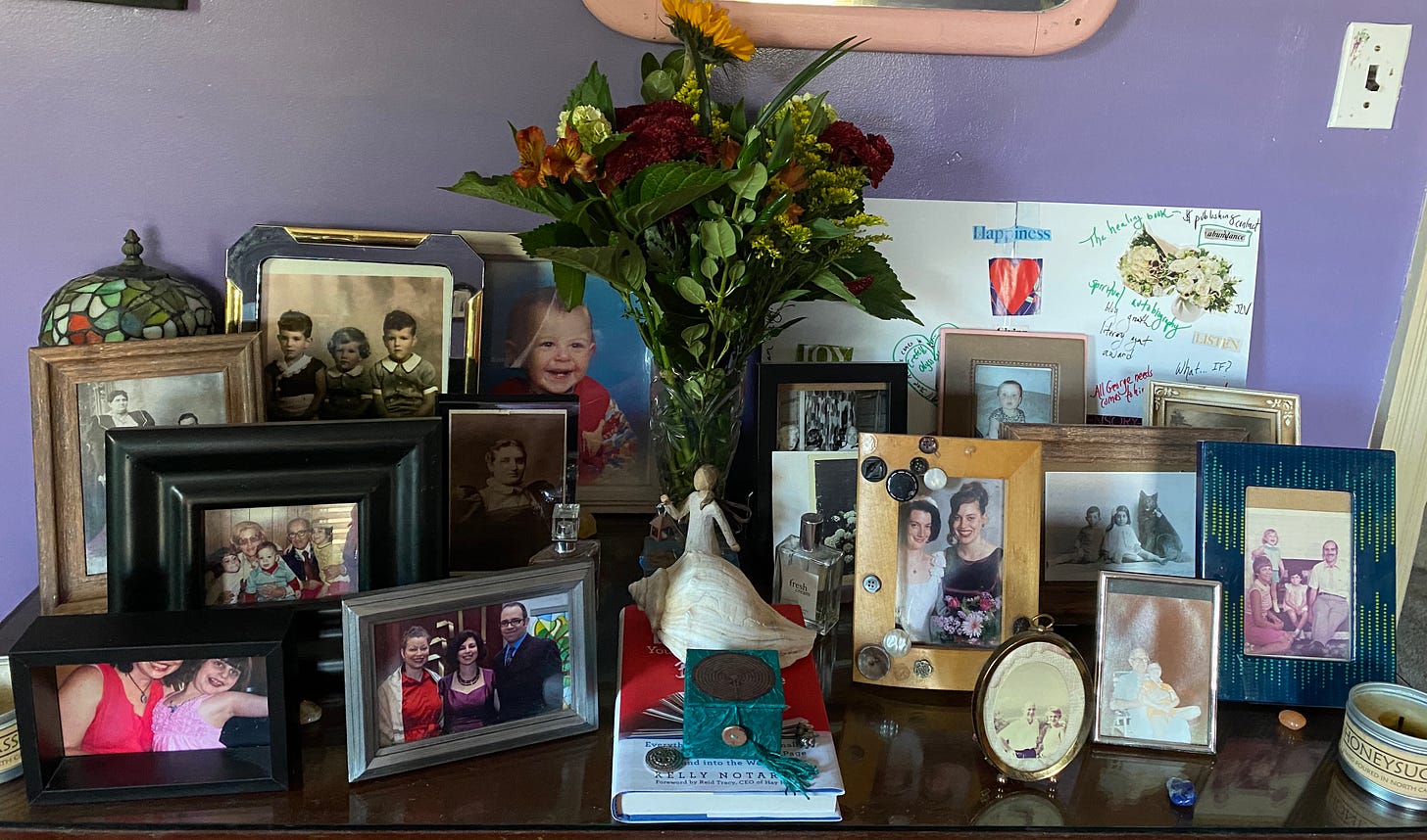 a collection of framed photos, flowers and candles