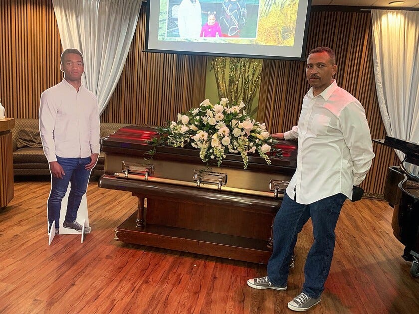 Joseph Green poses with his son's casket. 