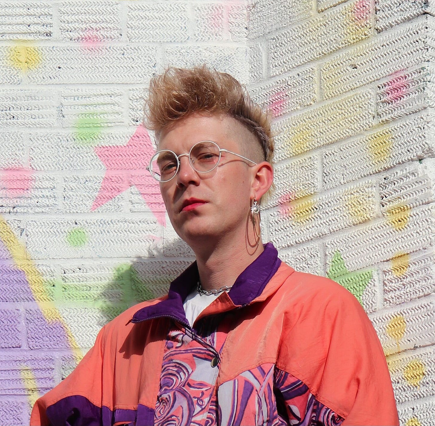 Head and shoulders photo of T S Idiot in a colourful orange and purple jacket