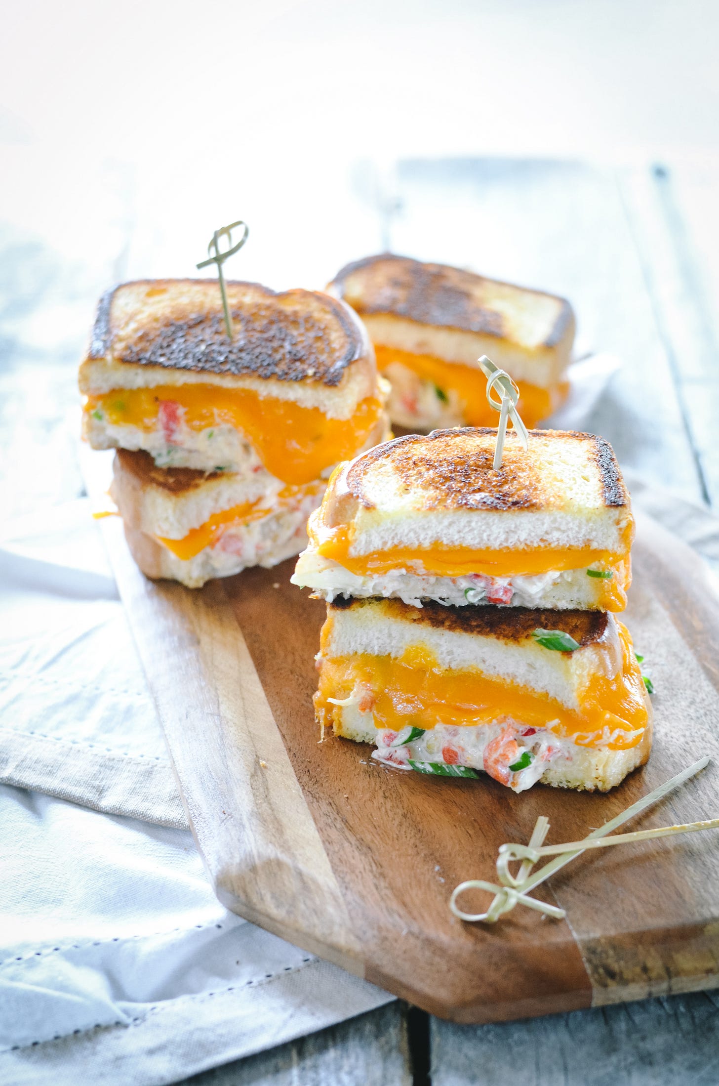 Photo of Grilled Cheese and Dungeness Crab Sandwiches on a wooden board