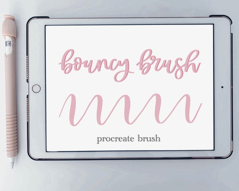 May include: A digital tablet displays the words "bouncy brush" and "procreate brush" in pink script. Below the text is a wavy pink line. A stylus with a pink grip rests beside the tablet.