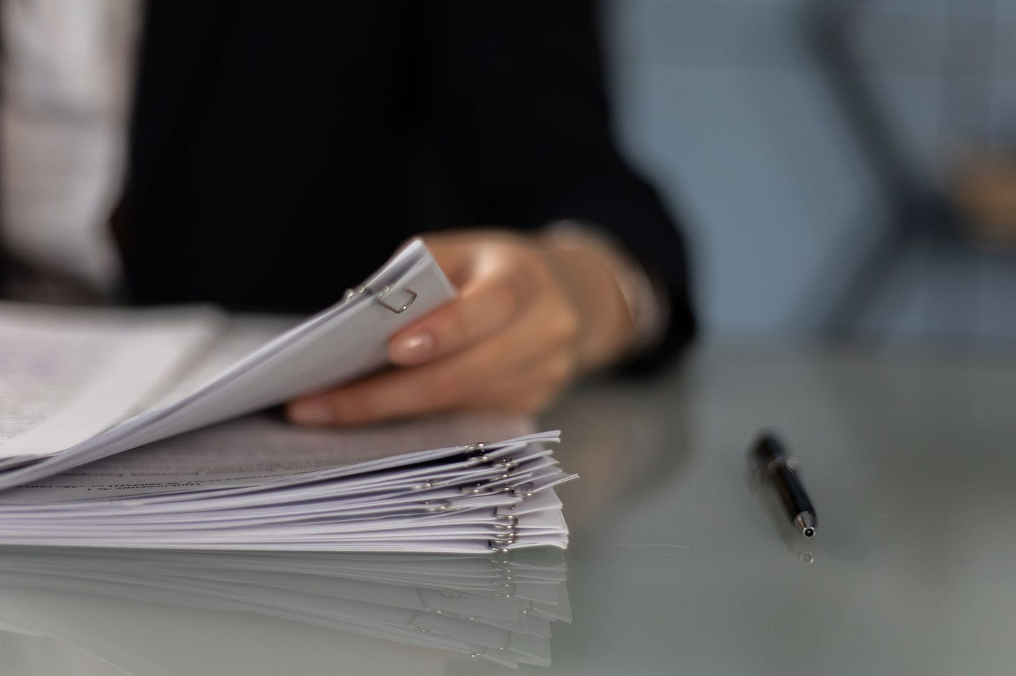 Photo by KATRIN BOLOVTSOVA on Pexels Close-up of a professional organizing a stack of documents on a desk. (stock photo)