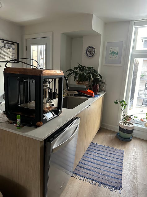 A custom 3D printer designed to look like solar punk, with black 3D printed anatomy models of reproductive organs.