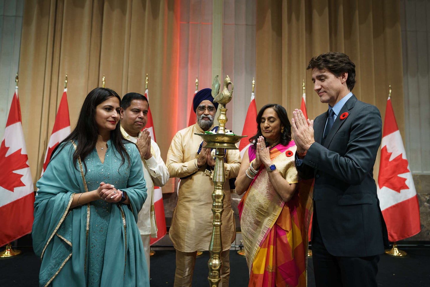 Prime Minister Justin Trudeau, members of Cabinet, and members of the Hindu community are in front of a diya at a Diwali celebration in Ottawa.