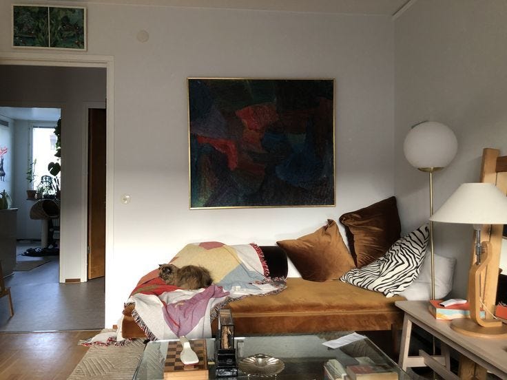 This may contain: a living room filled with furniture and a painting hanging on the wall above a coffee table