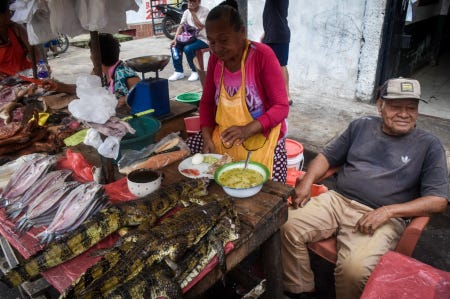 Des petits caïmans morts, d'environ 60 centimètres, en vente sur un marché péruvien
