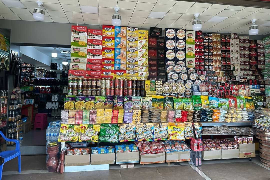 A store next to a customs station in Hekou county in Southwest China’s Yunnan province sells snacks, slippers, bead strings and other goods imported from Vietnam on Nov. 3. Photo: Feng Yiming/Caixin