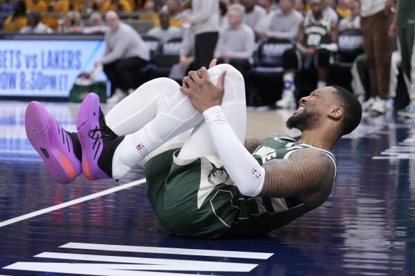 Milwaukee Bucks guard Damian Lillard (0) grabs his leg after being injured during the first half in Game 2 against the Indiana Pacers in an NBA basketball first-round playoff series, Friday, April 26, 2024, in Indianapolis. (AP Photo/Michael Conroy) Milwaukee Bucks guard Damian Lillard (0) grabs his leg after being injured during the first half in Game 2 against the Indiana Pacers in an NBA basketball first-round playoff series, Friday, April 26, 2024, in Indianapolis. (AP Photo/Michael Conroy)