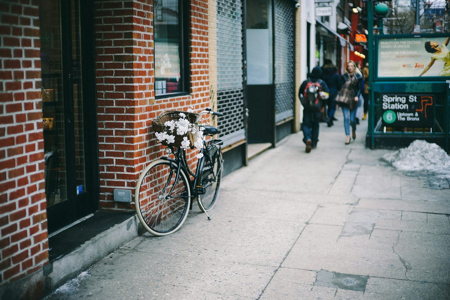 black city bicycle parked beside brown concrete brick wall in new york city