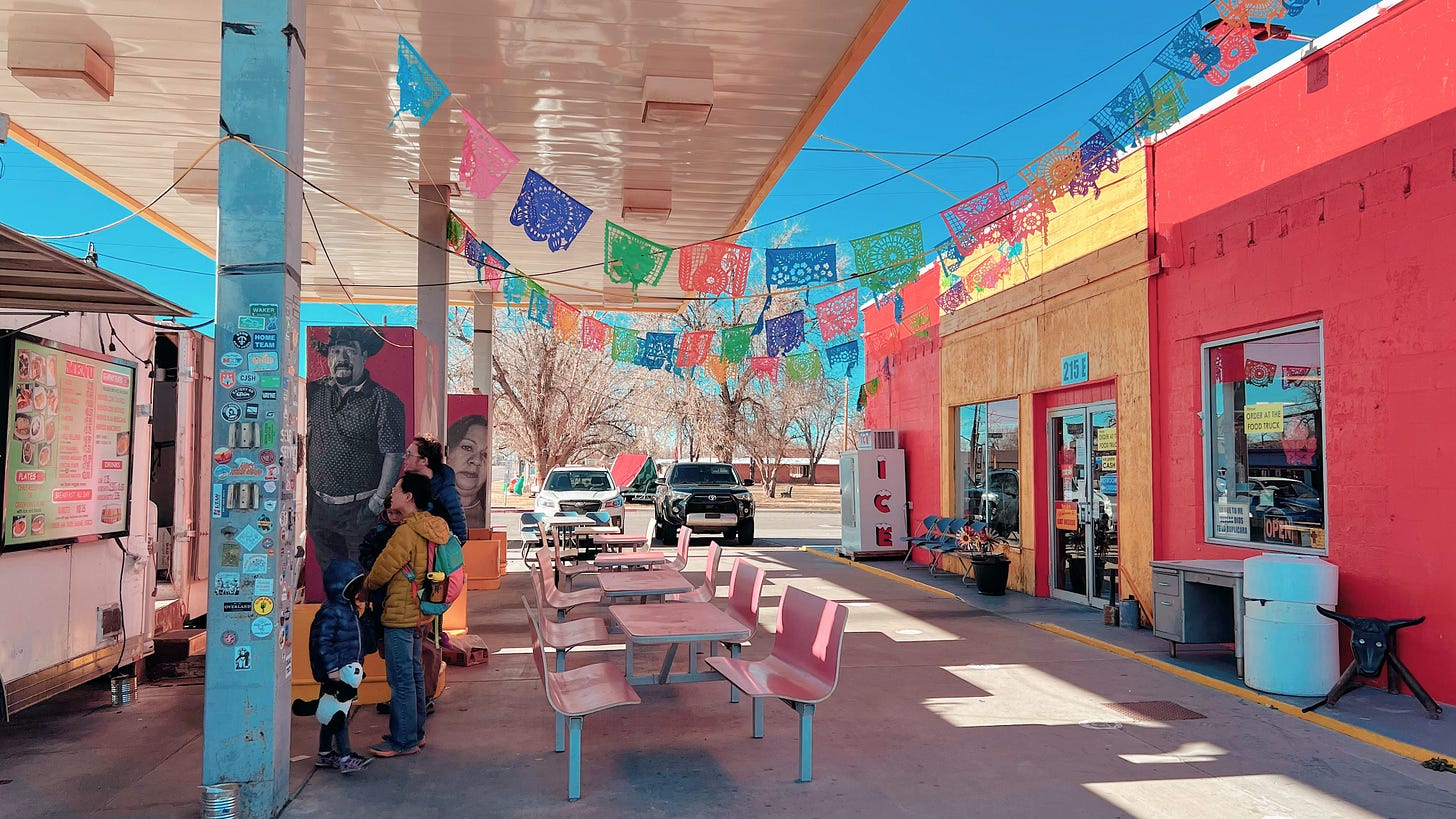 Green River, Utah. The pumps are gone; the canopy is still useful. A family makes lunch underneath.