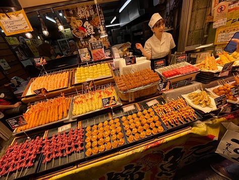 A collage of nine photos from travels in Japan: two sumo wrestlers posing with visitors; vintage kabuki posters on display; a small group sitting on tatami mats during a cultural workshop; a mannequin dressed in a traditional kimono with floral patterns; three people smiling in front of a lantern-filled temple gate; a night market vendor grilling skewers and takoyaki; two friends taking a selfie in Shibuya among bright city signs; the waterfront skyline and Ferris wheel in Yokohama; and a narrow alleyway in Kyoto lined with glowing izakaya lanterns.