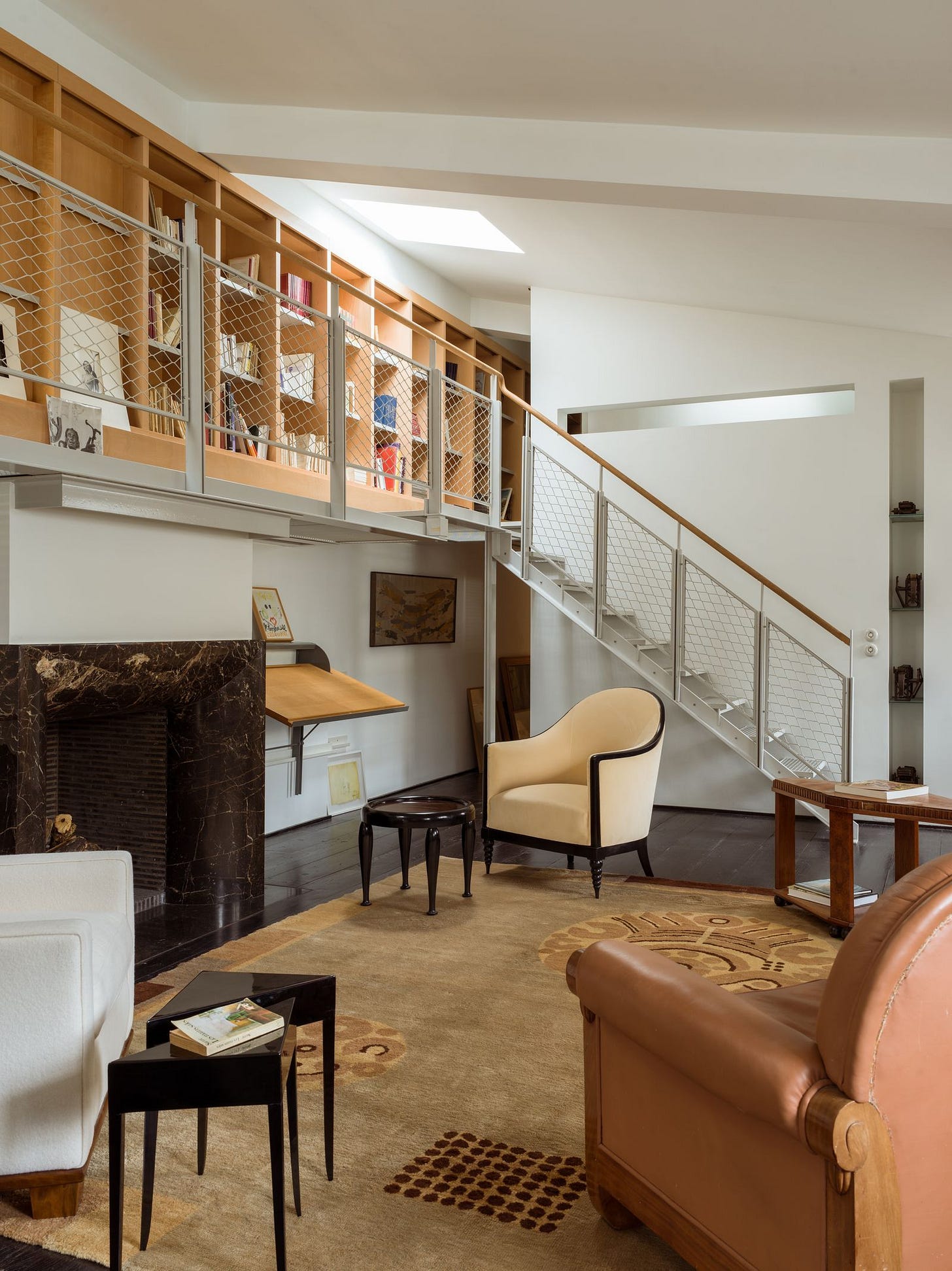 Devant la chemine en marbre d'Andre Putman un fauteuil blanc Jacques Adnet 1939  et deux tables d'appoint laques noires... Devant la chemine en marbre d'Andre Putman un fauteuil blanc Jacques Adnet 1939  et deux tables d'appoint laques noires...