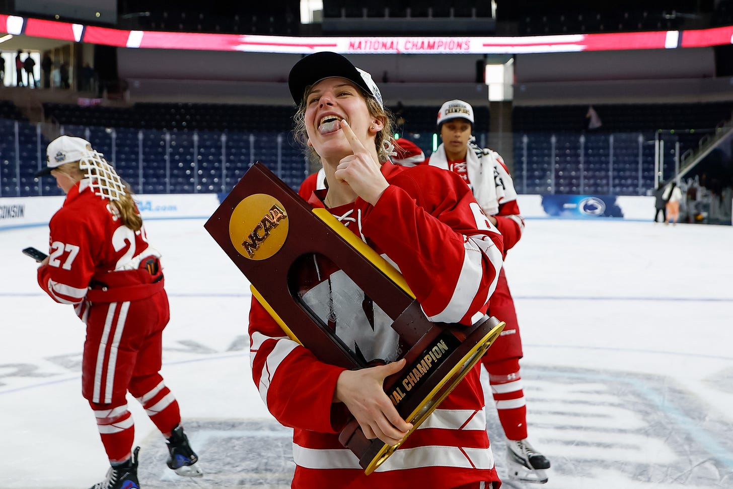 Lacey Eden skates with the national championship trophy and sticks her tongue out