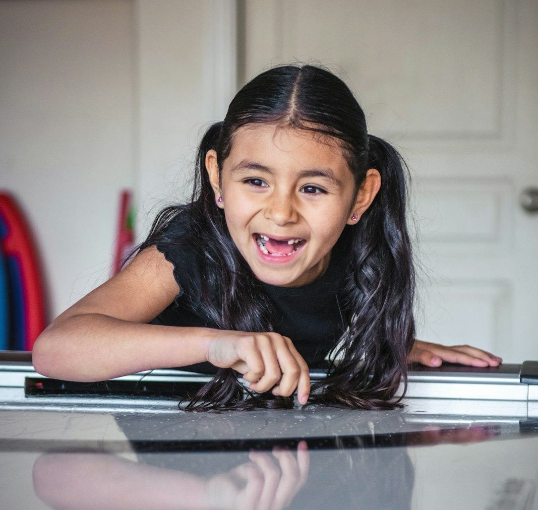 a little girl laying on top of a piano a little girl laying on top of a piano