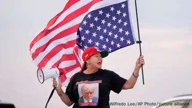 Woman with Trump t-shirt holding an American flag