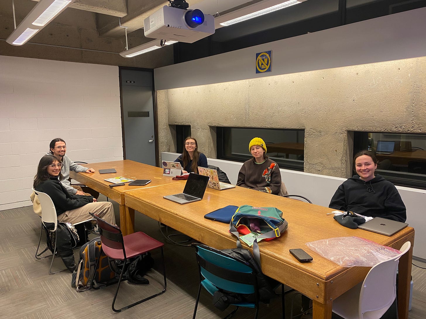 5 people sitting around a wood table
