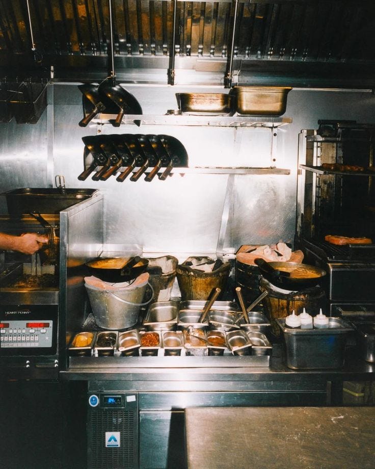 This may contain: an industrial kitchen with pots and pans on the stove This may contain: an industrial kitchen with pots and pans on the stove