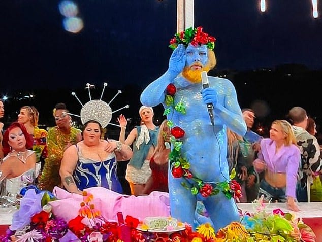 A performer painted blue and covered in flowers and fruit, depicting the Greek god Dionysus, sang in French A performer painted blue and covered in flowers and fruit, depicting the Greek god Dionysus, sang in French