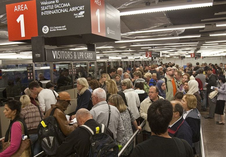 A crowd waits in the international arrivals area at Sea-Tac Airport. A new app could help some travelers get through passport/customs control at Sea-Tac more quickly.  (Mike Siegel/The Seattle Times)