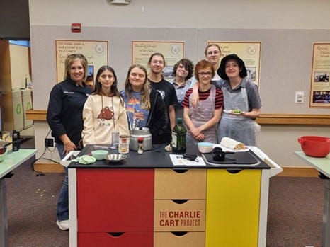 Teen Cuisine: Chop It Up! Program leaders and teens next to a Charlie Cart.