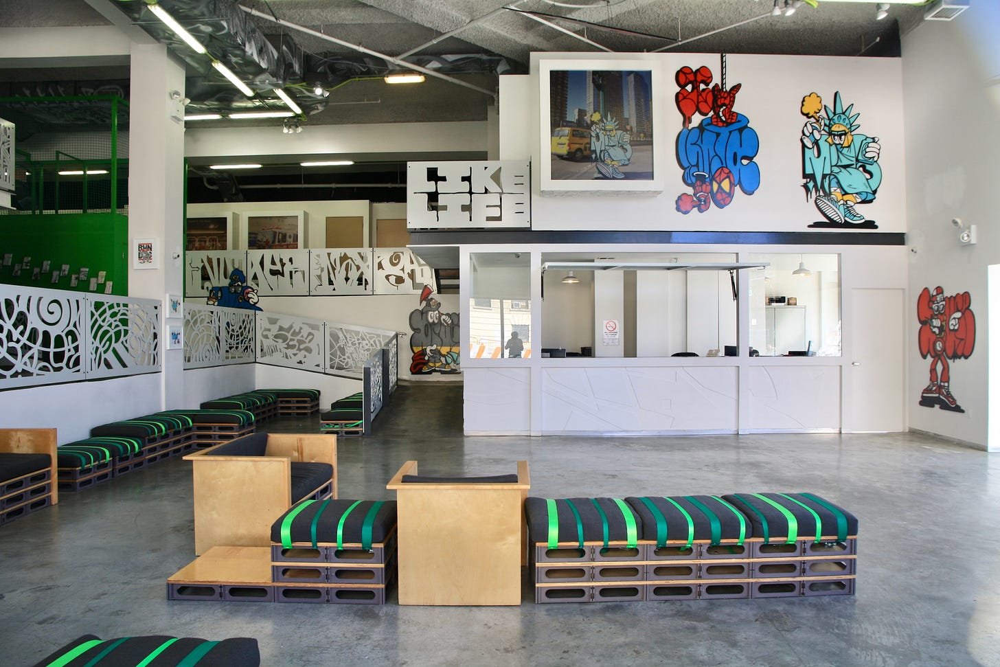 The interior of a pediatric clinic features inventive graffiti art, brightly colored upholstered benches and railings whimsically carved.