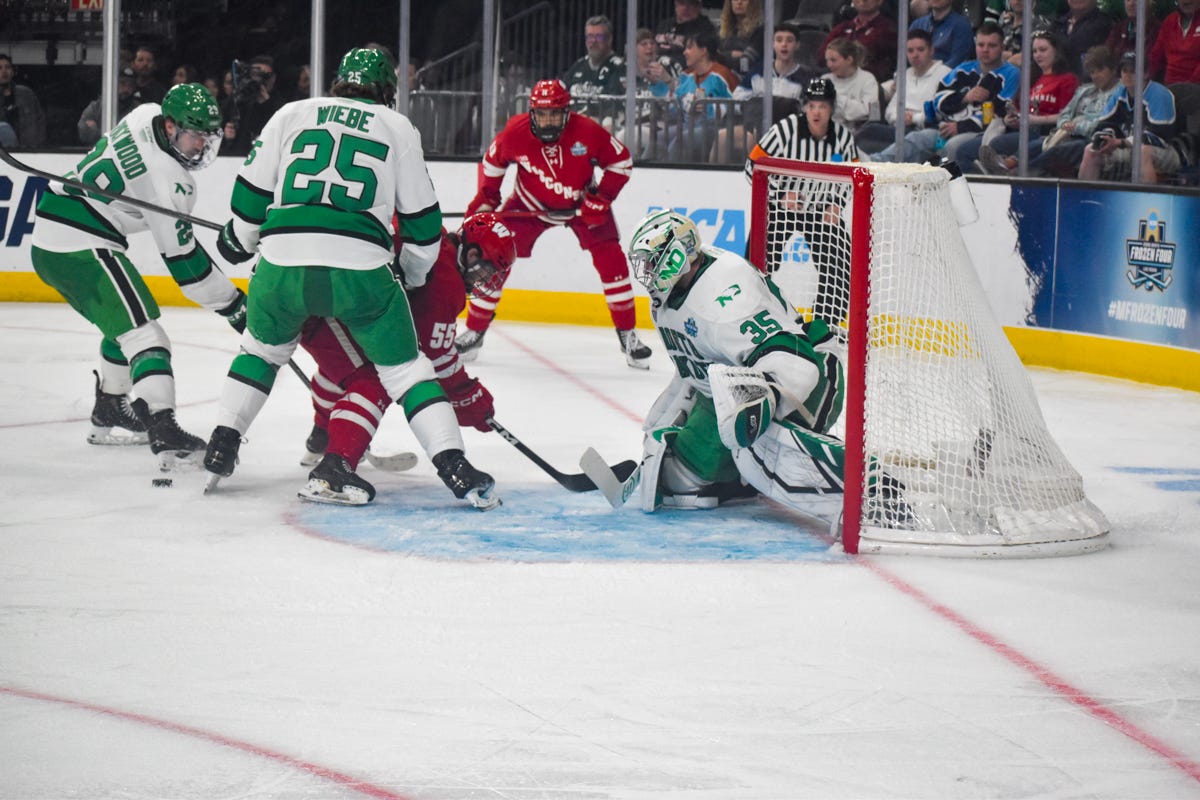 Players mob near North Dakota hockey goalie