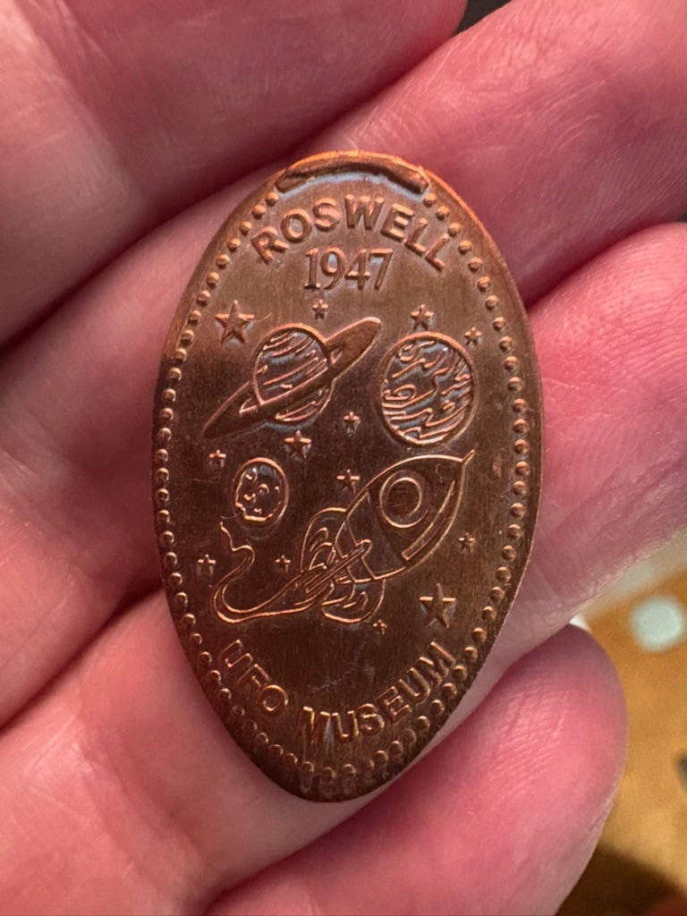 hand holding a souvenier penny from Roswell, NM