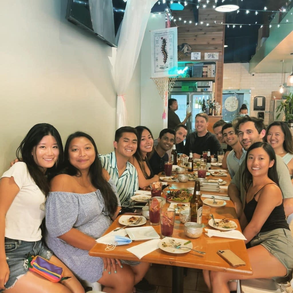 Mangione, 26, is seen in the far back, second from the right, with a wide grin while surrounded by more than a dozen of his friends out at a restaurant in Hawaii. Instagram @tracy.meomeo