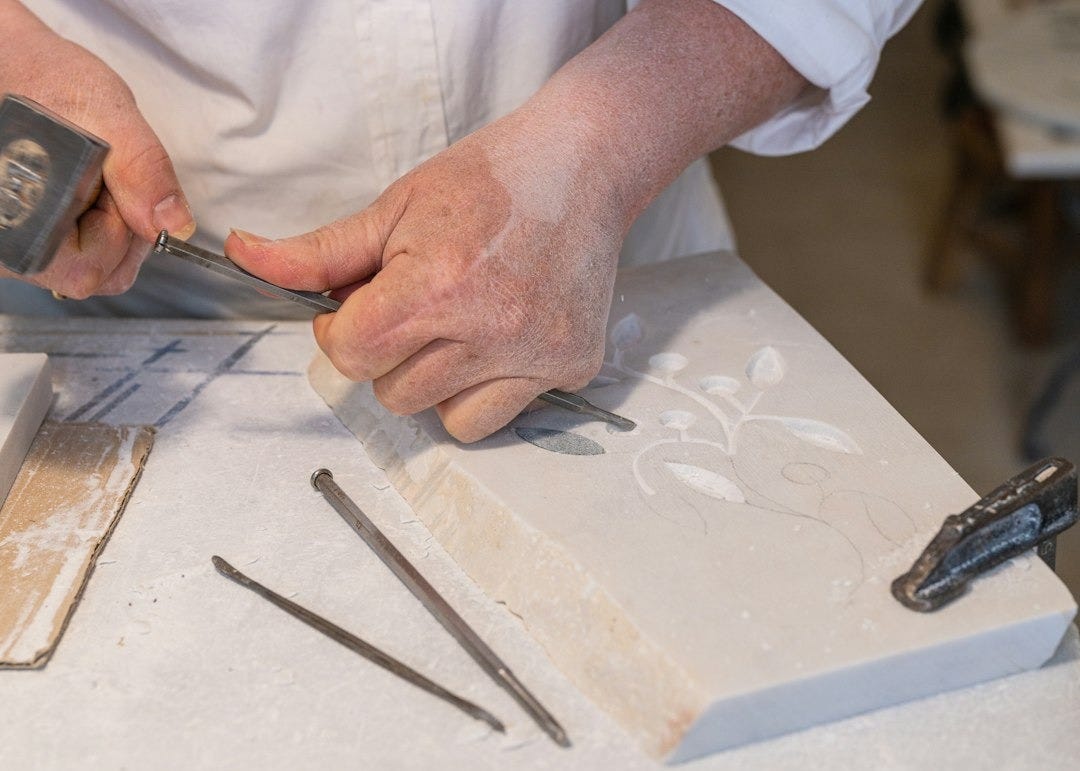 a person using a pair of scissors to cut a piece of wood