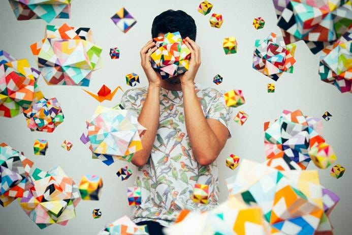 A person holding his face in front of many colorful paper cubes

AI-generated content may be incorrect.