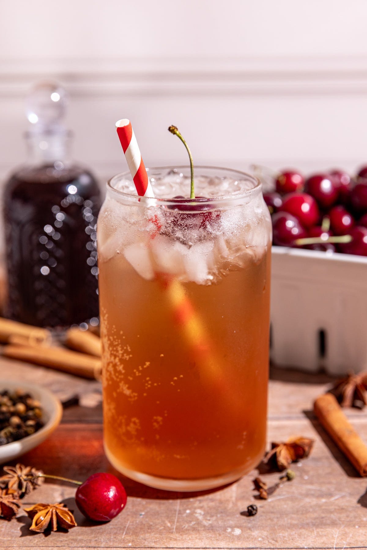 A soda glass of homemade Dr. Pepper with a cherry garnish and red & white striped straw. A soda glass of homemade Dr. Pepper with a cherry garnish and red & white striped straw.