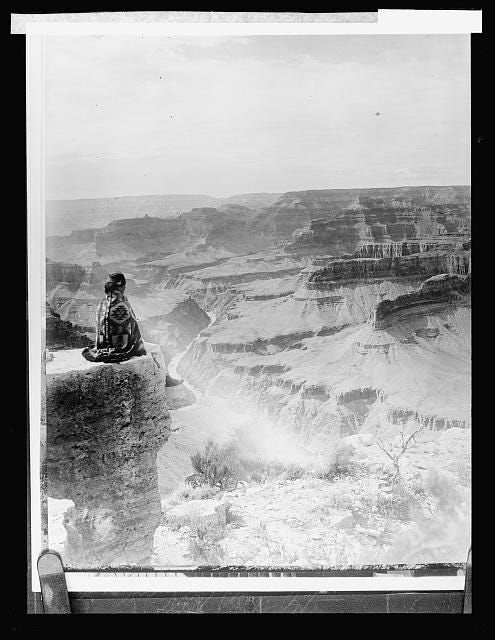 [Native American seated on the edge of the Grand Canyon, Arizona]