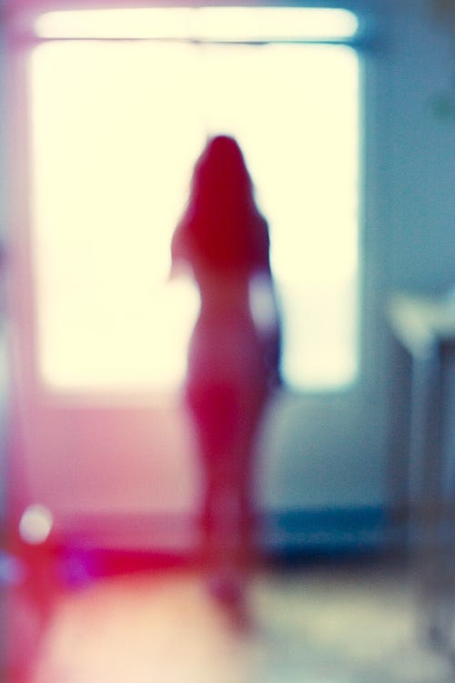 This may contain: a blurry photo of a person standing in front of a window