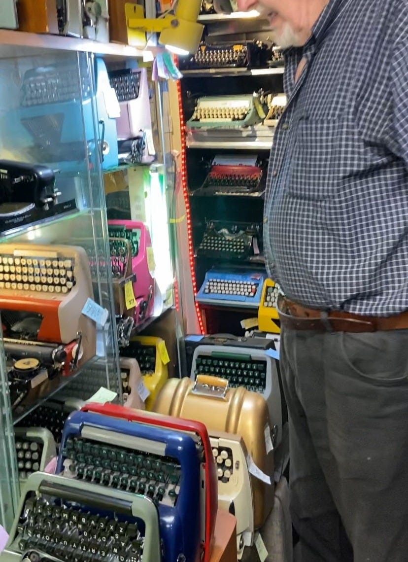 White man surrounded by vintage typewriters. White man surrounded by vintage typewriters.