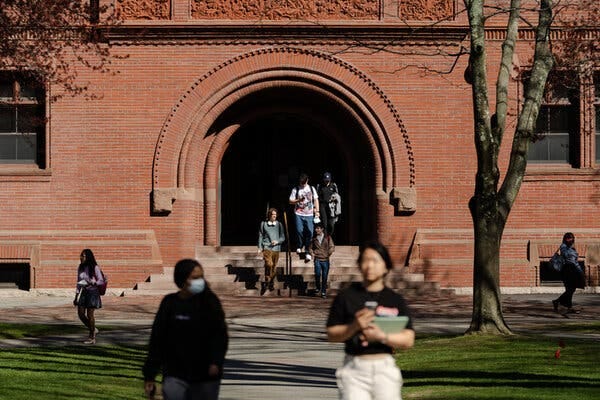 Students, some carrying books, cut across Harvard Yard. Students, some carrying books, cut across Harvard Yard.