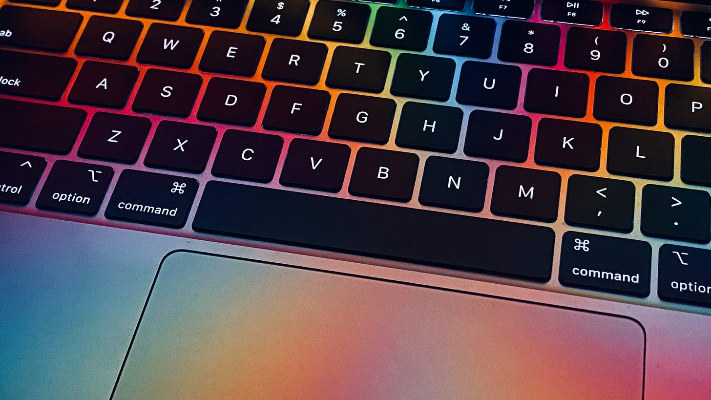 MacBook keyboard with rainbow lighting.