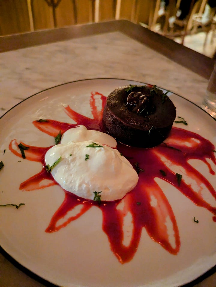Left to right: Creme brûlée cheesecake over a splattering of raspberry sauce; chocolate ganache cake with whipped cream over raspberry sauce 
